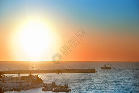 海面上的日落橙子阳光天际海洋季节海浪海岸反射旅行天空图片