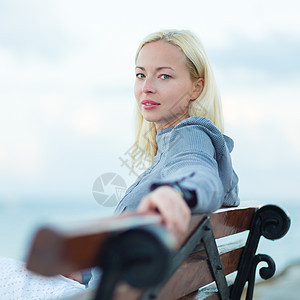 女士坐在户外的长椅上蓝色支撑喜悦思维假期女孩地平线旅行福利风景图片