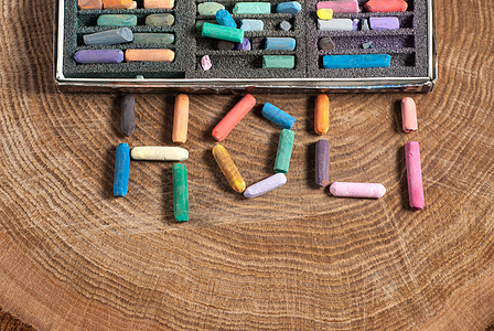 木制桌上的Holi这个词空间多样性蜡笔艺术家染色艺术桌子粉彩设计师工作图片