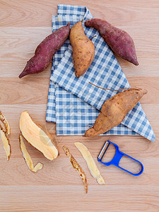 切除两种甜土豆品种 在生锈的呼牛上加剥皮机麸质营养养分番薯橙子收成块茎农业木头蔬菜图片