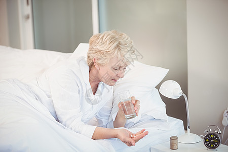 女人在床上休息时吃药图片