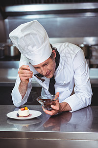 厨师在甜点上加巧克力酱汁厨师长职业男人厨房黑板厨艺推介会板块制服餐厅图片