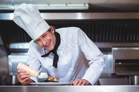 厨师在意大利面盘上加酱汁食物厨艺职业准备厨房制服盘子面条男性黑板图片