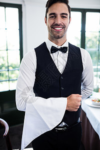 服务员对着镜头微笑的肖像职业制服工作餐厅快乐服务器领结酒店马甲男性图片