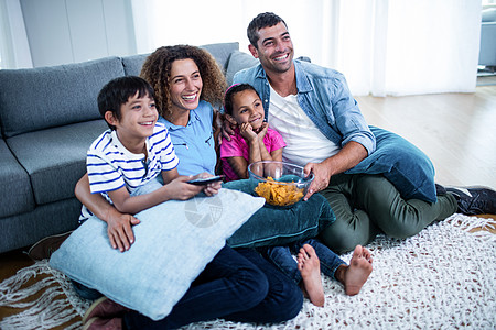 家庭在电视上观看美式足球比赛男人扇子女儿枕头欢呼公寓喜悦小地毯父亲男性图片