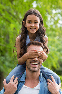父亲抱着她女儿肩膀男性女性快乐微笑乐趣享受男人公园亲密感感情图片