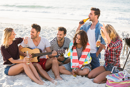 朋友在沙滩喝啤酒假期快乐音乐音乐家酒精友谊男人瓶子女性吉他图片