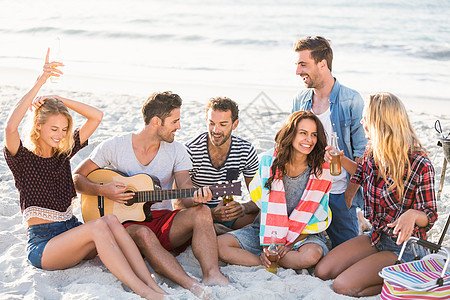 朋友在沙滩喝啤酒快乐男人海滩海洋晴天吉他微笑啤酒音乐家海岸线图片