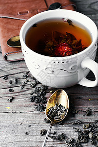 一杯茶饮料绿色草本香味叶子芳香黑色玫瑰花瓣勺子图片