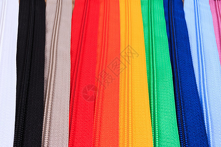 白色背景中六种不同颜色的彩色拉链红色裁缝缝纫紧固件紫色彩虹材料织物黄色宏观图片