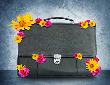 带鲜花的黑色手提箱案件灰色公文包背景旅行白色金属花朵图片