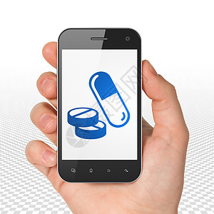医疗保健概念手持智能手机与显示屏上的药丸图片