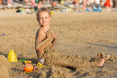 6岁女孩在沙滩上沾湿沙子 脸色很酸图片