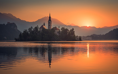 斯洛文尼亚布莱德湖日出时斯洛文士兰的教堂岛屿反射橙子旅行海浪旅游辉光地标日落太阳山脉图片