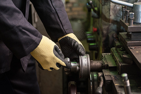 身戴保护手套的工人生产工具作坊劳动者机械金属机器劳动操作维修图片