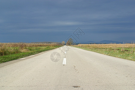 秋天在草地和田间之间空旷的道路速度剥离运动路线天空倾斜场地地平线旅行运输图片