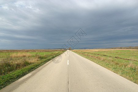 秋天在草地和田间之间空旷的道路地平线运动速度天空运输风景路线职业旅行倾斜图片