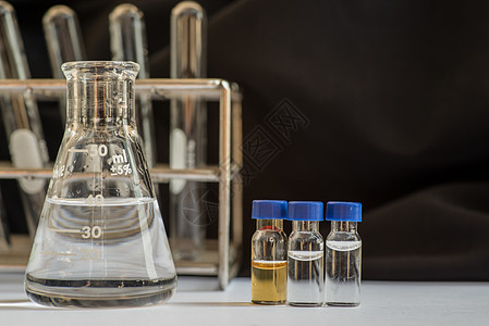 实验室玻璃器件前面的蓝盖小瓶器皿生物学微生物学学校技术瓶子科学家试管科学技术员图片