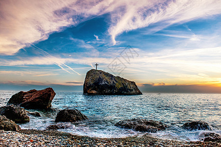 海滩日落场景蓝色天空海岸紫色晴天海景石头岩石太阳图片