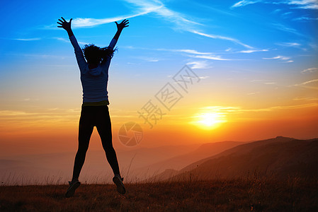 快乐跳跃的年轻女青年跳跃享受女性自由天空乐趣紫色阳光橙子幸福图片