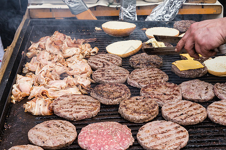 牛肉汉堡在食物摊烤架上被烤焦敷料餐饮手套摊位牛肉配料城市厨房猪肉餐厅图片