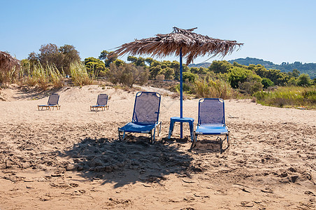 香蕉海滩上的阳床和草伞假期天堂阳伞晴天旅游海岸线太阳支撑热带天空图片