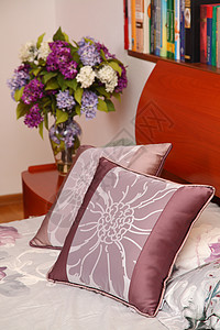 有花花花和枕头床的花瓶小桌住宅床头板软垫装饰床单桌子家具风格房间奢华图片