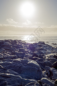白日落岩石上的海浪图片