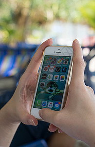 手持有家庭屏幕页面的iphone的妇女互联网服务电话社论女士细胞操作电子产品技术手机图片