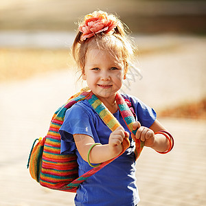 一个可爱的学龄前女孩的肖像 带着多彩编织冒充微笑情感头发快乐女性金发女郎背包喜悦童年图片