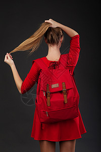 一个穿红裙子的女孩的肖像 背着一个大红背包图片