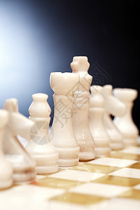 棋盘上的象棋片象棋头脑商业女王竞赛对抗石头休闲统治棋子背景图片