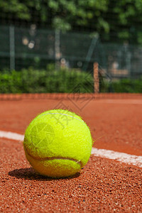 红土球场上的网球设备红色闲暇基线射线球拍黄色背光黏土竞赛法庭图片