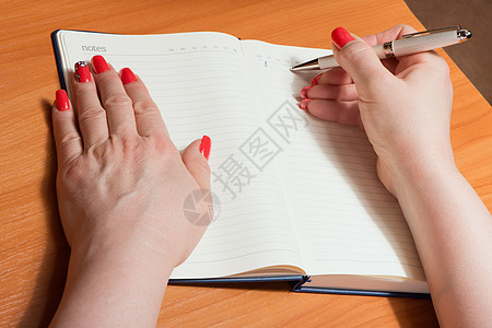 笔记本页上涂指甲的女性手经理文档成人艺术美甲手指铅笔插图桌子顾问图片