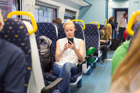 妇女在乘火车旅行时使用移动电话电话商业秘书运输通勤者技术管理人员女性乘客讲话图片