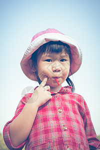 可爱的亚洲小女孩 吃棒棒棒糖 在自然背景图片