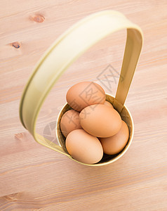 复活节鸡蛋在篮子里黄色木头柳条棕色蓝色动物食物抹布贮存杂货图片