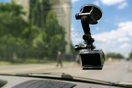 车挡风玻璃窗上挂有吸管盖的动作相机图片