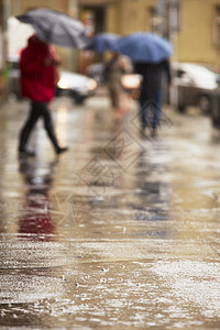 人们在雨中倾盆大雨团体风暴城市水坑雨滴运动旅行人行道建筑图片