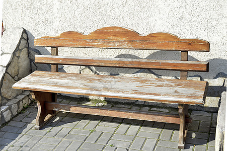 站在一个露天铺面地区的旧木板老旧空长椅小路装饰品绿色木头孤独椅子休息棕色座位家具图片