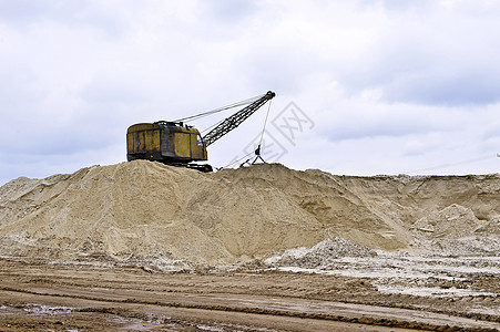在采石场工作的挖掘机生产沙子 在采石场工作的挖掘机生产沙子图片