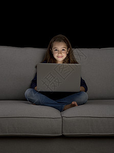 小女孩用笔记本电脑工作孩子们快乐童年沙发互联网娱乐儿童教育长椅学习图片