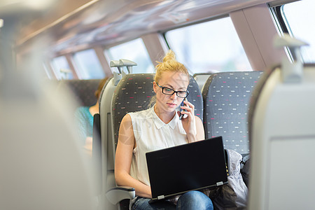 商业妇女乘火车旅行时从事工作通勤者讲话眼镜公共汽车商务电话乘客运输笔记本互联网图片