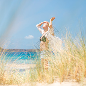 自由快乐的女子在节日中享受阳光冥想衬衫海滩太阳女孩旅行喜悦假期沙丘幸福图片
