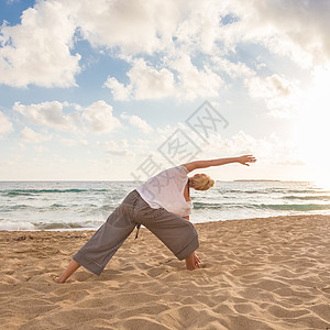 日落时在海边做瑜伽的女人身体运动海洋活力自由女孩海滩支撑阴影天空图片