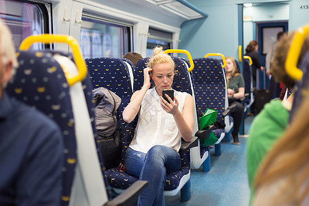 妇女在乘火车旅行时使用移动电话运输管理人员秘书铁路乘客女士通勤者商业互联网手机图片