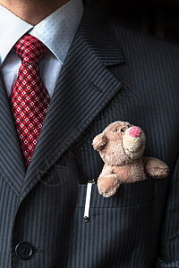 优雅的时尚商务人士把可爱的泰迪熊放在他的胸衣口袋里 正式的谈判概念胸部老板父亲银行领带夹克衬衫经理人士男人图片