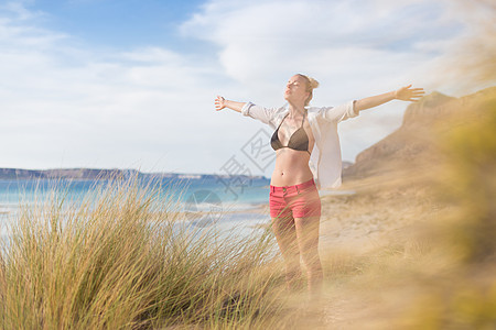 自由快乐的女子在节日中享受阳光女性女孩海滩生活喜悦沙丘太阳冥想幸福衬衫图片