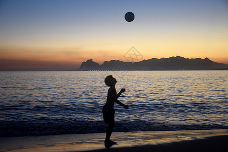 海滩日落时踢足球情感孩子运动太阳男生旅游晴天天空海洋热带图片