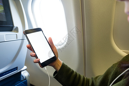 妇女在飞机内使用手机;高清图片